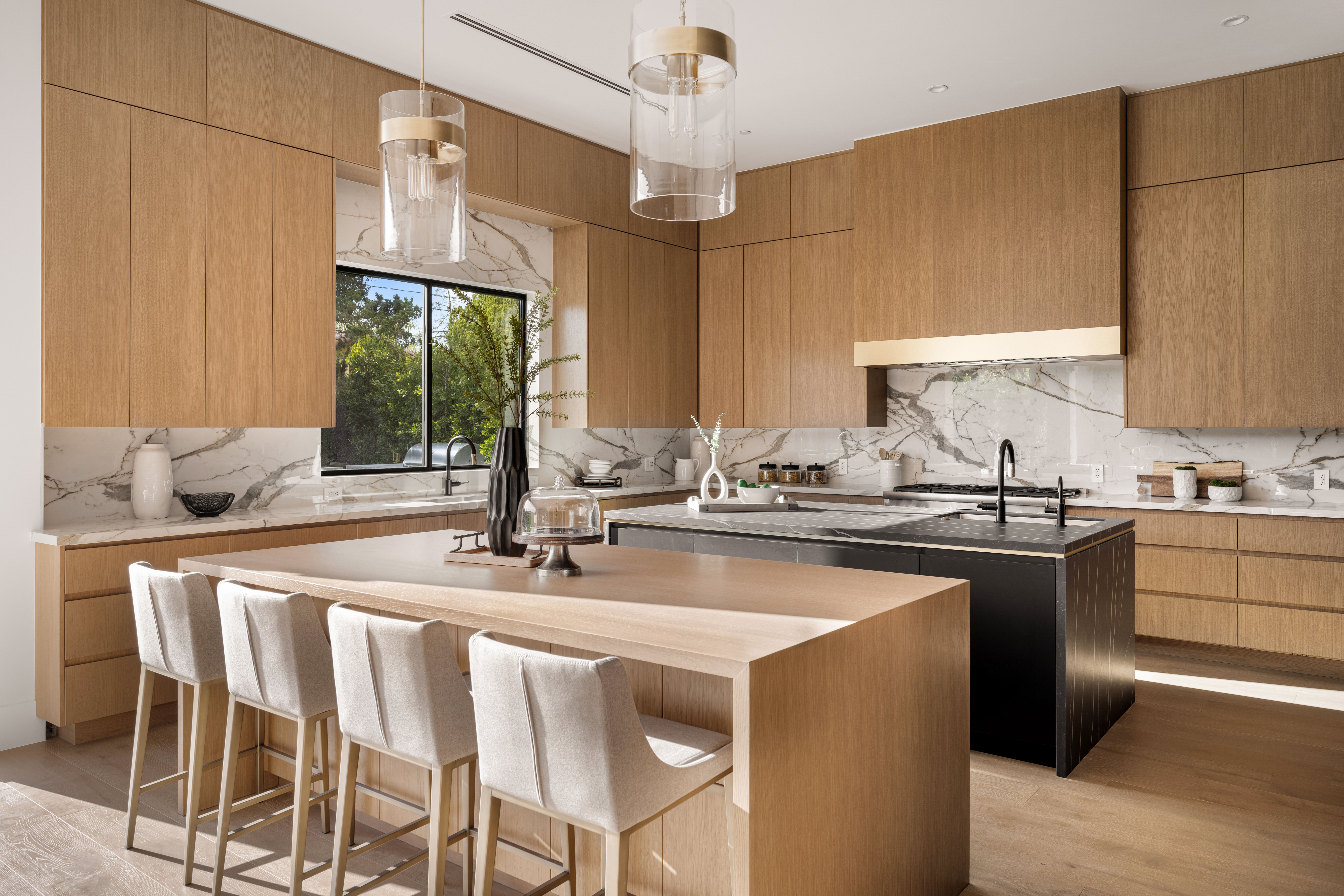 Modern kitchen with wooden cabinets and marble countertops.