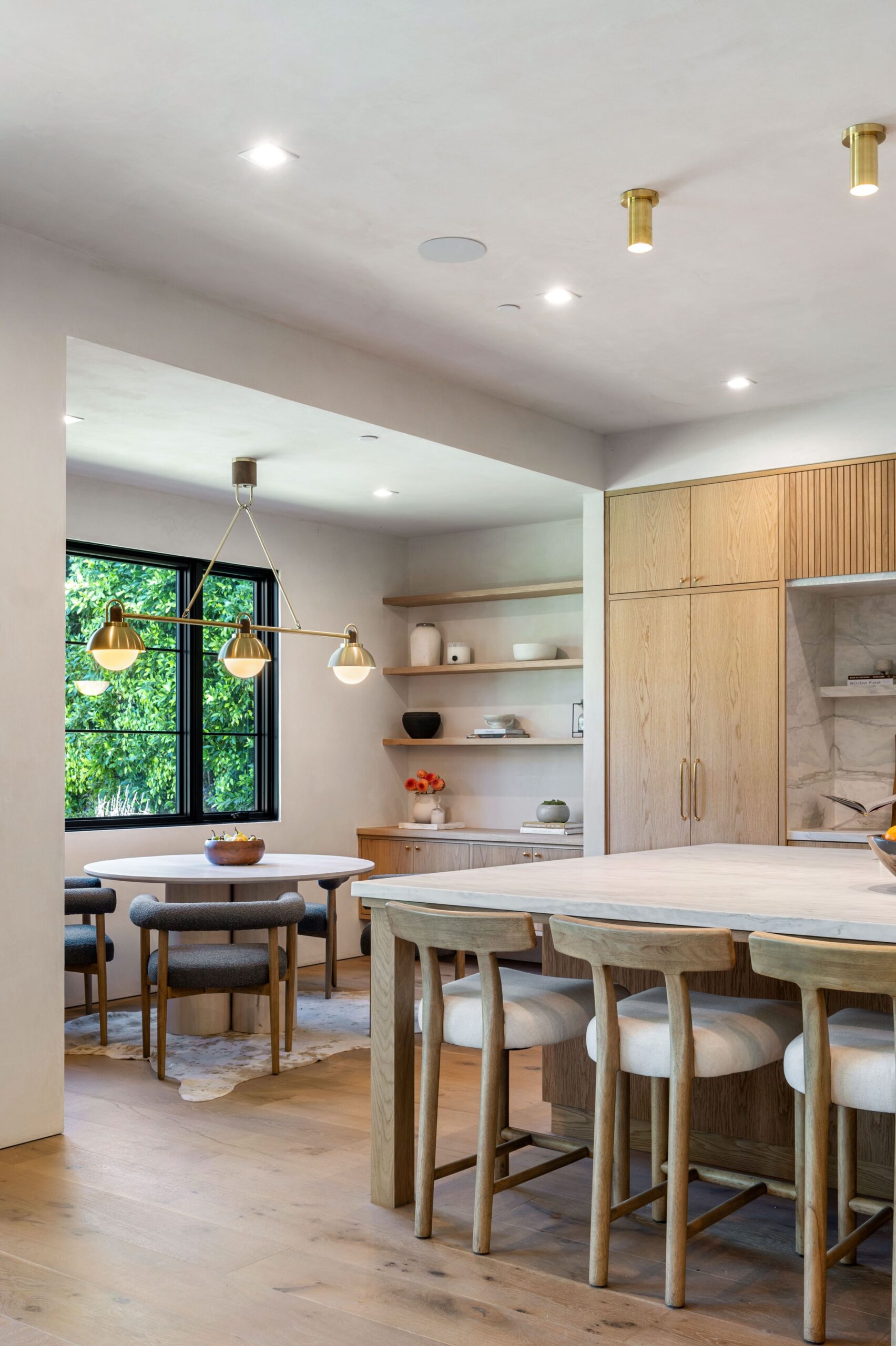 Modern kitchen with wooden furniture and elegant lighting.